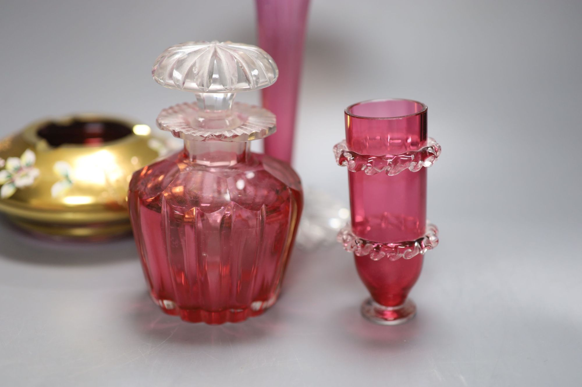 Six pieces of cranberry glass and a later bohemian ashtray, tallest 21cm